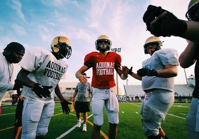 John O'Korn calls a play in the huddle during practice at St. Thomas Aquinas High School.