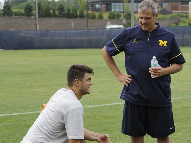 John O'Korn talks with Gary O'Korn during a youth football camp at Schembechler Hall.